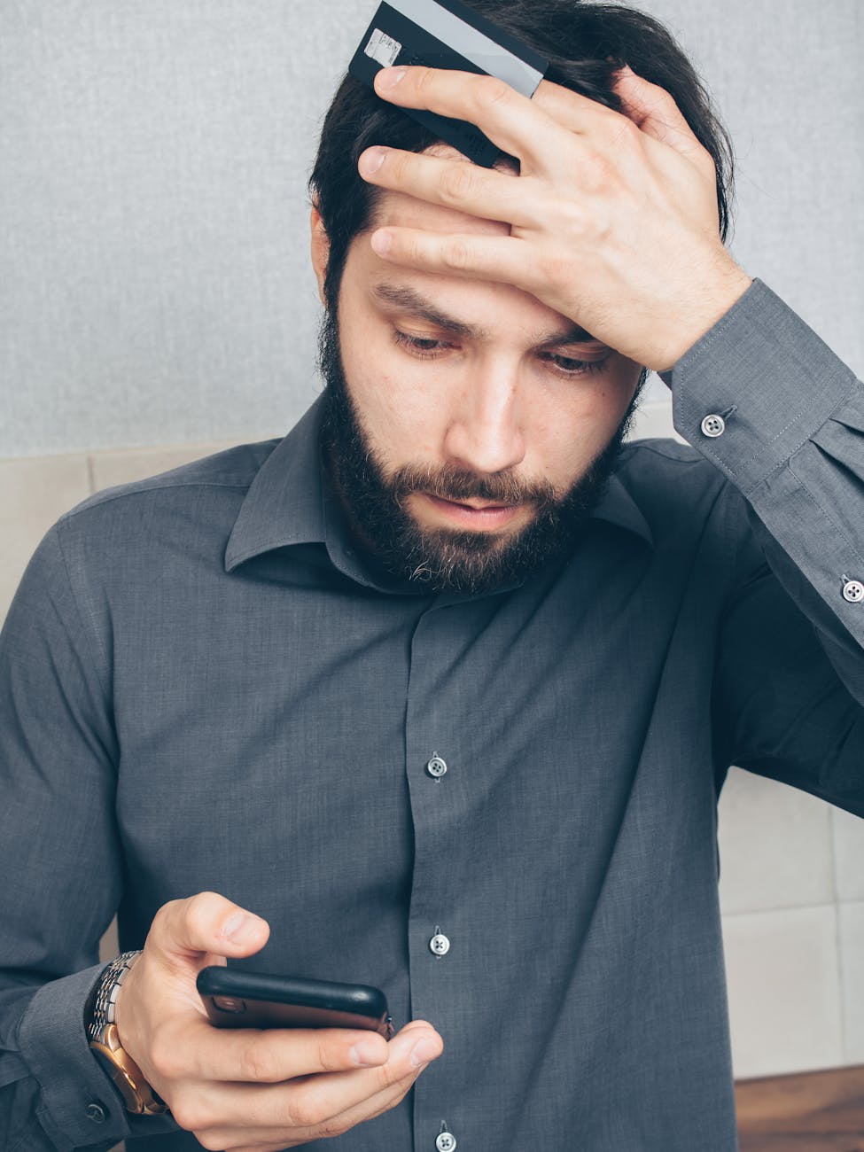 man in black button up shirt holding smartphone